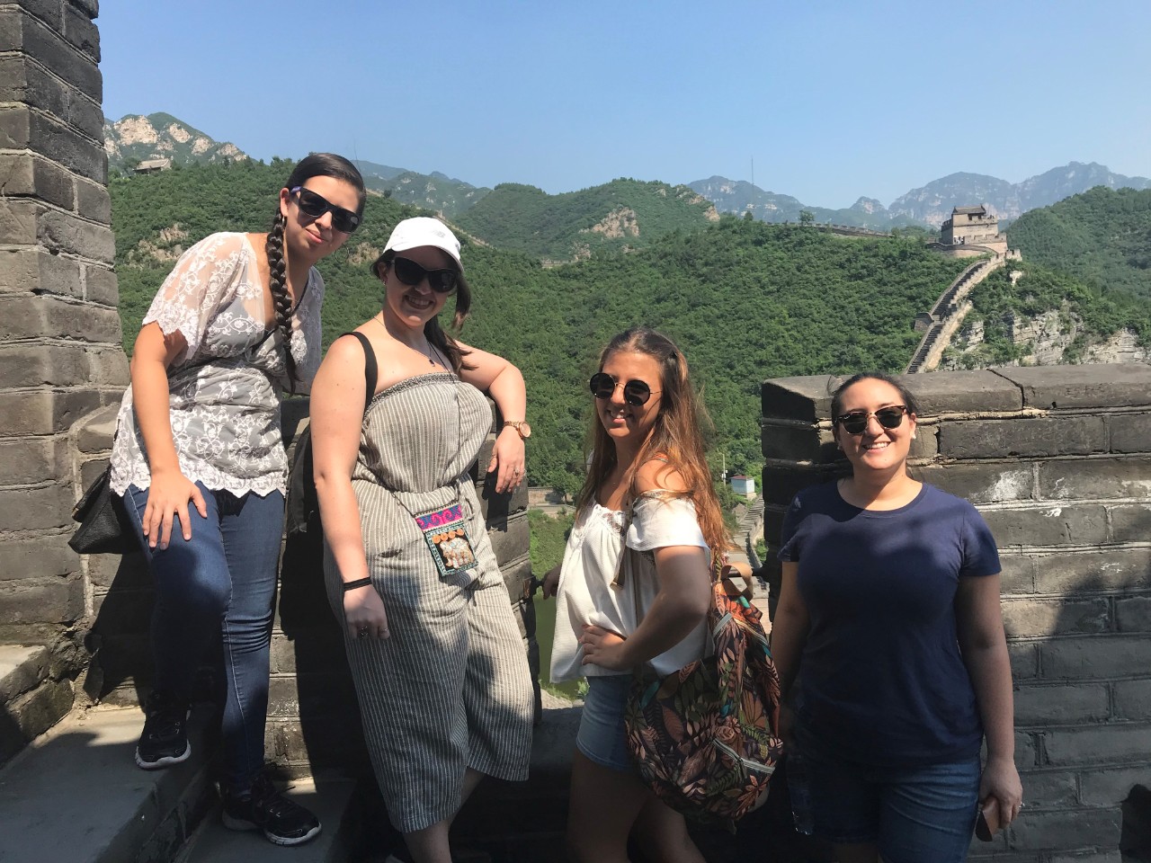 4 students posing with the Great Wall as their backdrop