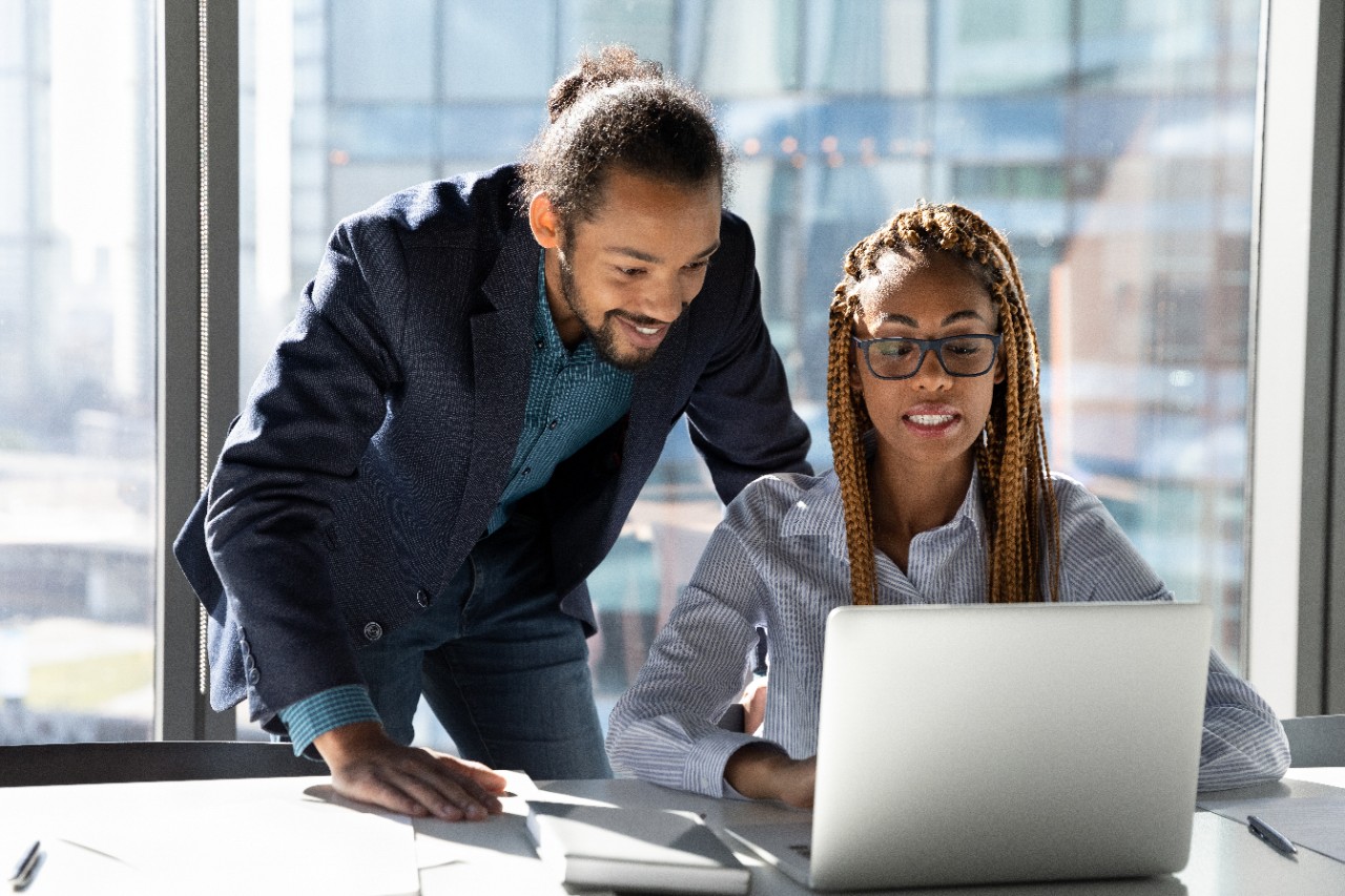 Male and female colleagues analyzing together on the computer in the office