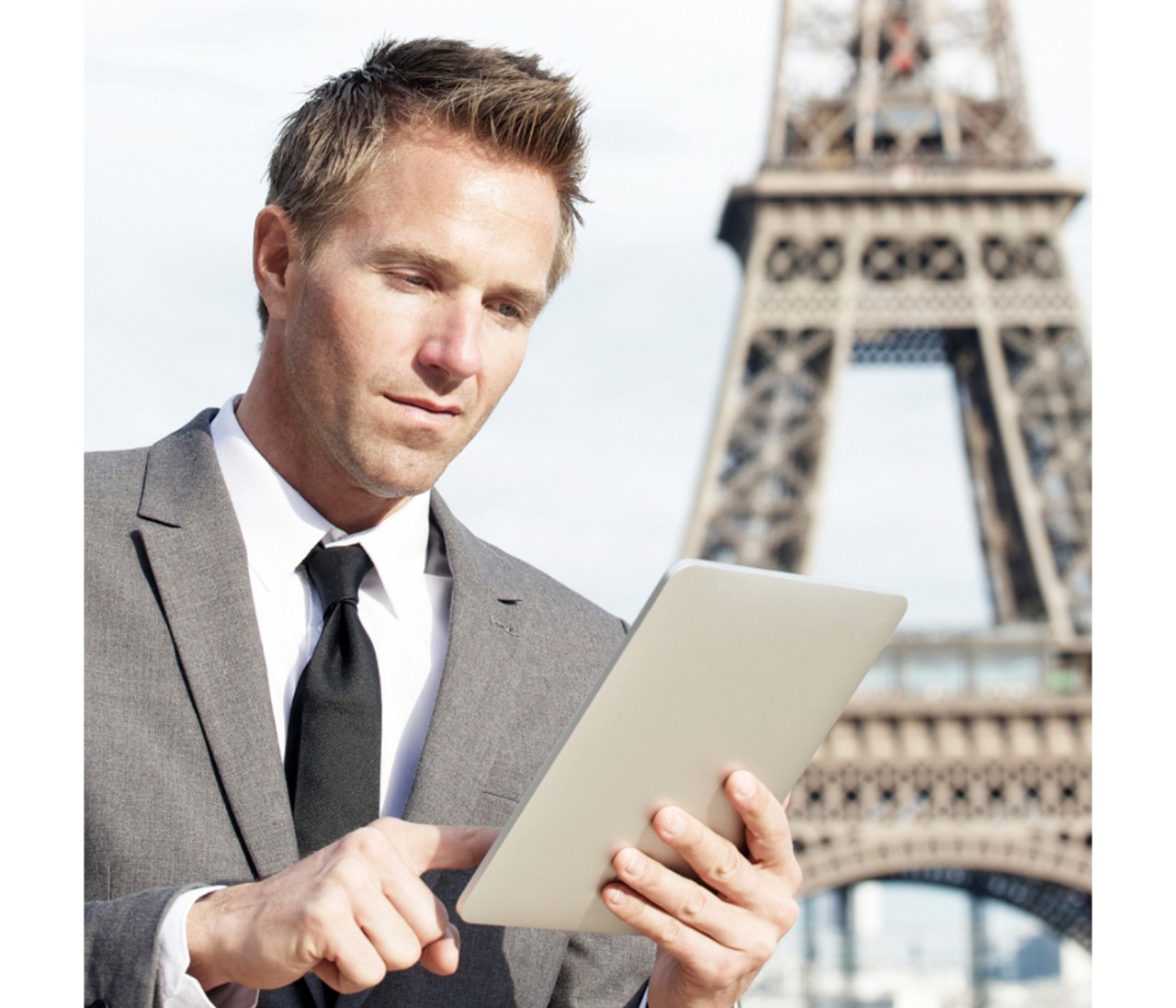 Man on tablet in front of Eiffel Tower