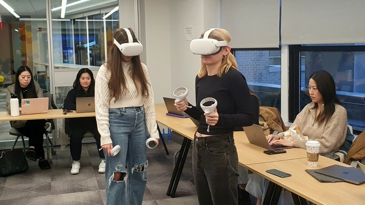 Two women using VR headset and equipment