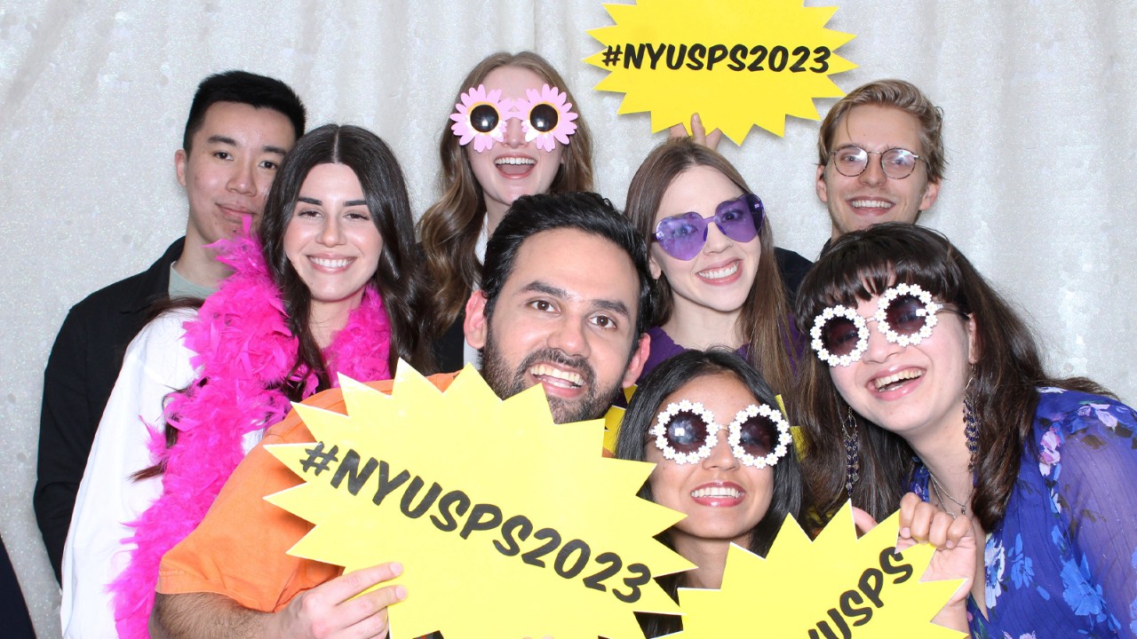 Students group photo holding sign #NYUSPS2023