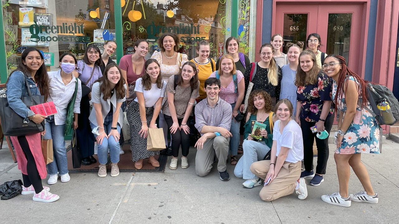 Students pose in front of the mural at Books Are Magic in Brooklyn. 