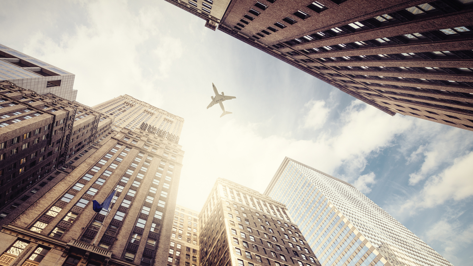 Buildings with plane flying over